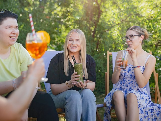 Guests enjoying live music and outdoor dining on the sunny terrace of PURE Restaurant at Sheraton Offenbach.
